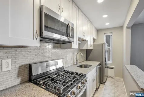 a kitchen with stainless steel appliances granite countertop a refrigerator stove and microwave