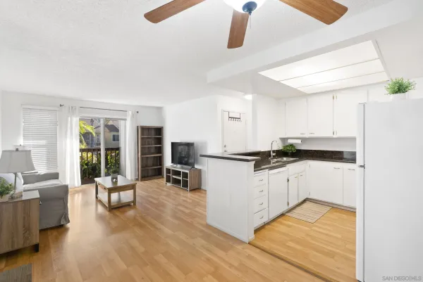 a kitchen with stainless steel appliances granite countertop a stove a sink dishwasher and a dining table with wooden floor