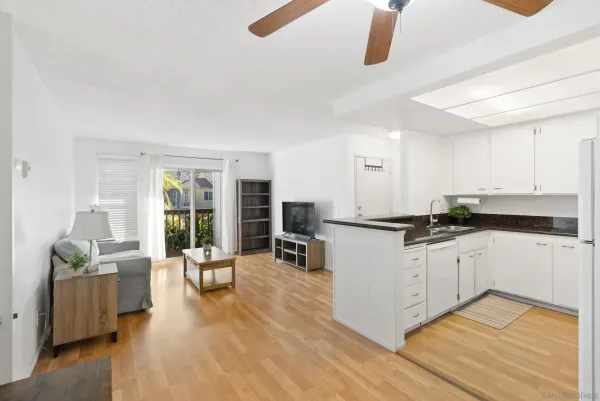 a living room with furniture a flat screen tv and a floor to ceiling window