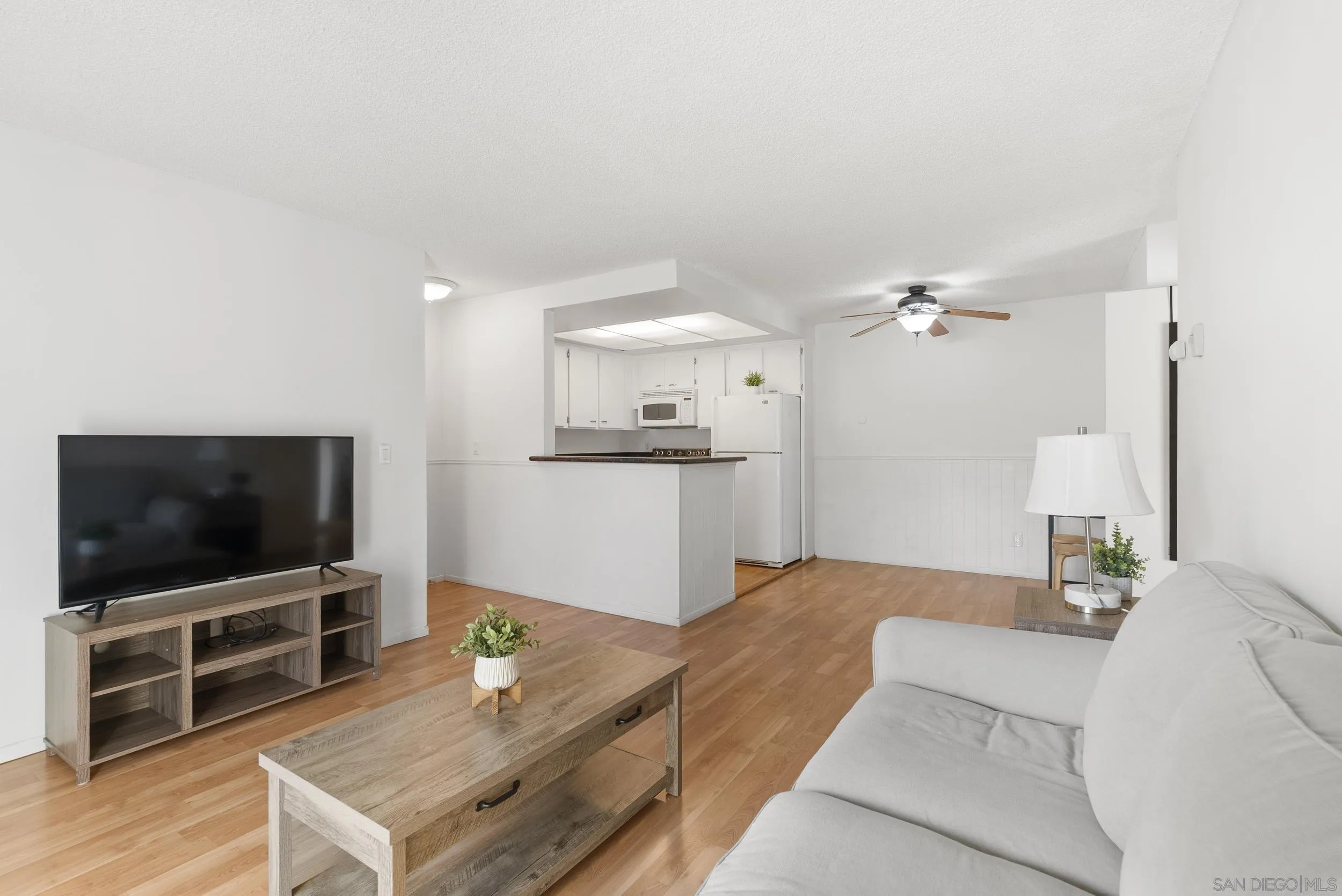 5978 Rancho Mission Road, Unit 274 San Diego, CA 92108 - Photo 6 of 23 a living room with furniture and a flat screen tv