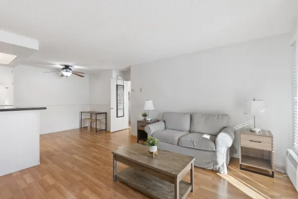 a living room with furniture flat screen tv and large windows