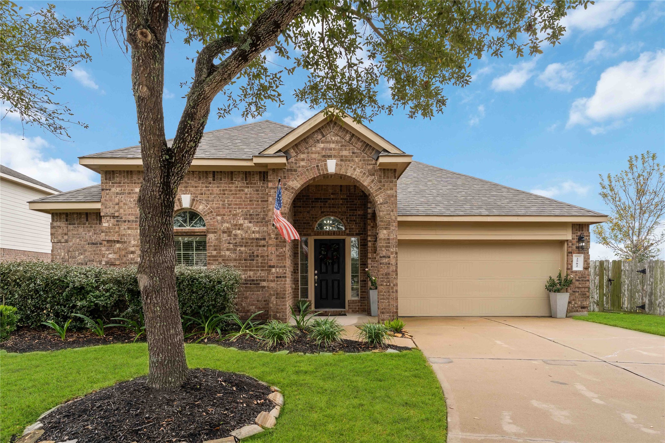 Charming brick home with a welcoming arched entryway.

