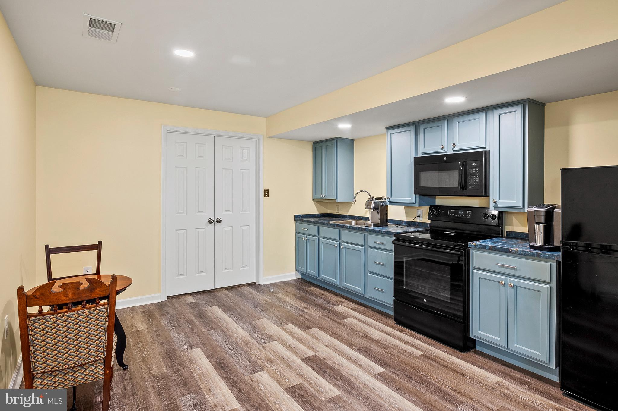 456 North Patuxent Road Odenton, MD 21113 - Photo 31 of 44 a kitchen with granite countertop a stove top oven a sink dishwasher a dining table and chairs with wooden floor