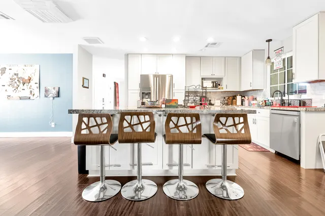 a view of a kitchen with granite countertop a stove and wooden floor