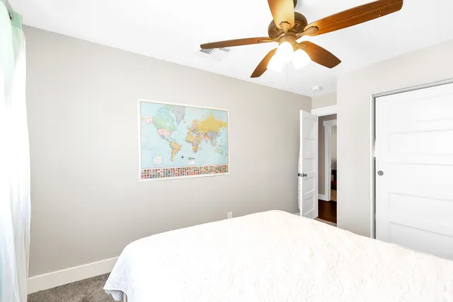 a bedroom with a bed and a painting on the wall