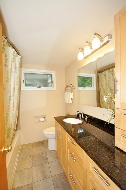 138 Tower Road Lincoln, MA 01773 - Photo 13 of 23 a spacious bathroom with a granite countertop sink a toilet a mirror and a bathtub