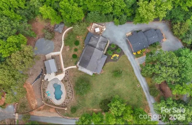 an aerial view of a house with a yard and trees
