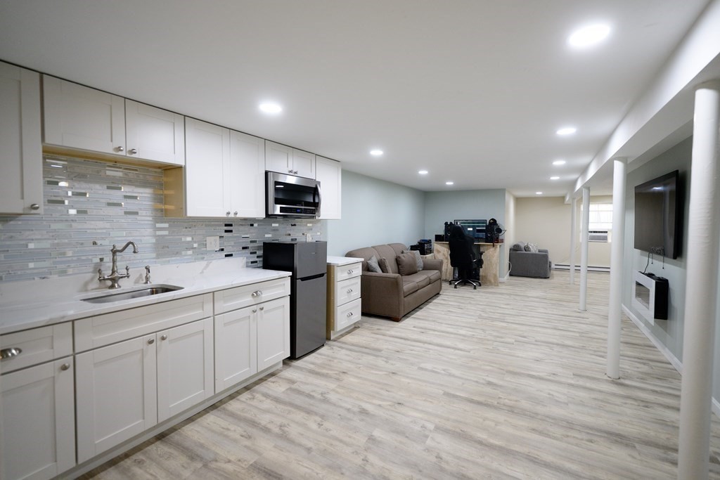 462 Goldthwaite Road Northbridge, MA 01588 - Photo 33 of 40 a large white kitchen with stainless steel appliances granite countertop a stove a sink dishwasher and a microwave with wooden floor