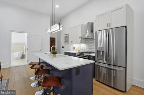 a kitchen with kitchen island a wooden floor and white appliances