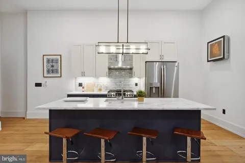 a kitchen with stainless steel appliances a table and chairs in it
