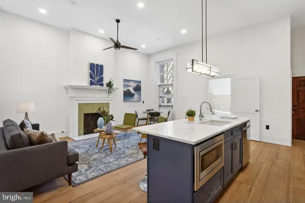 a living room with furniture a fireplace and wooden floor