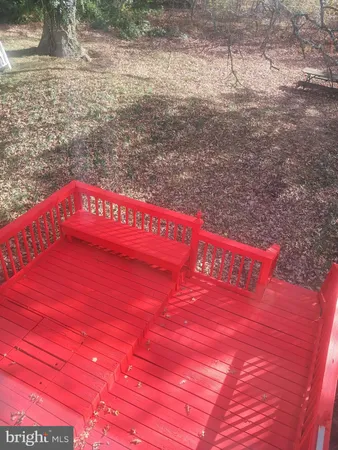 a view of an empty room with wooden floor and a fireplace