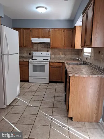 a kitchen with a stove a sink and a refrigerator