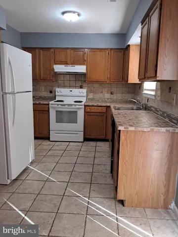 a kitchen with a stove a sink and a refrigerator