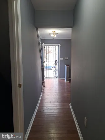 a view of a hallway with wooden floor and windows