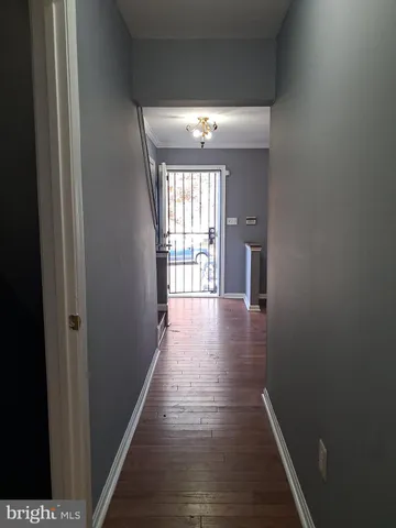 a view of a hallway with wooden floor and windows