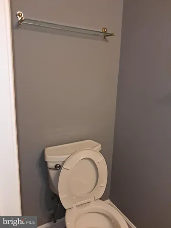 a white toilet sitting next to a shower