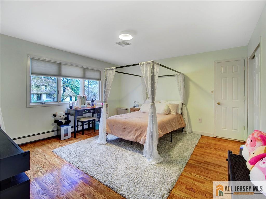 4 Cherokee Road East Brunswick, NJ 08816 - Photo 22 of 40 a bedroom with a bed and wooden floor