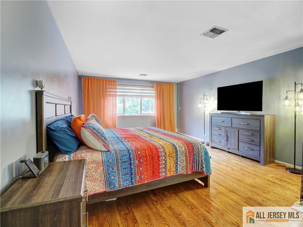 4 Cherokee Road East Brunswick, NJ 08816 - Photo 26 of 40 a bedroom with a bed and a flat screen tv