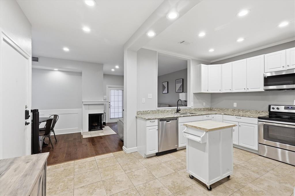 14277 Preston Road, Unit 615 Dallas, TX 75254 - Photo 9 of 20 a large kitchen with stainless steel appliances granite countertop a stove a sink a refrigerator and white cabinets