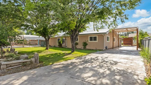 a view of a house with backyard and a tree