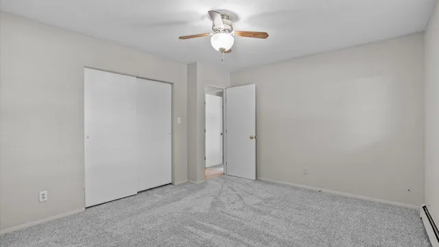 a view of an empty room and chandelier fan