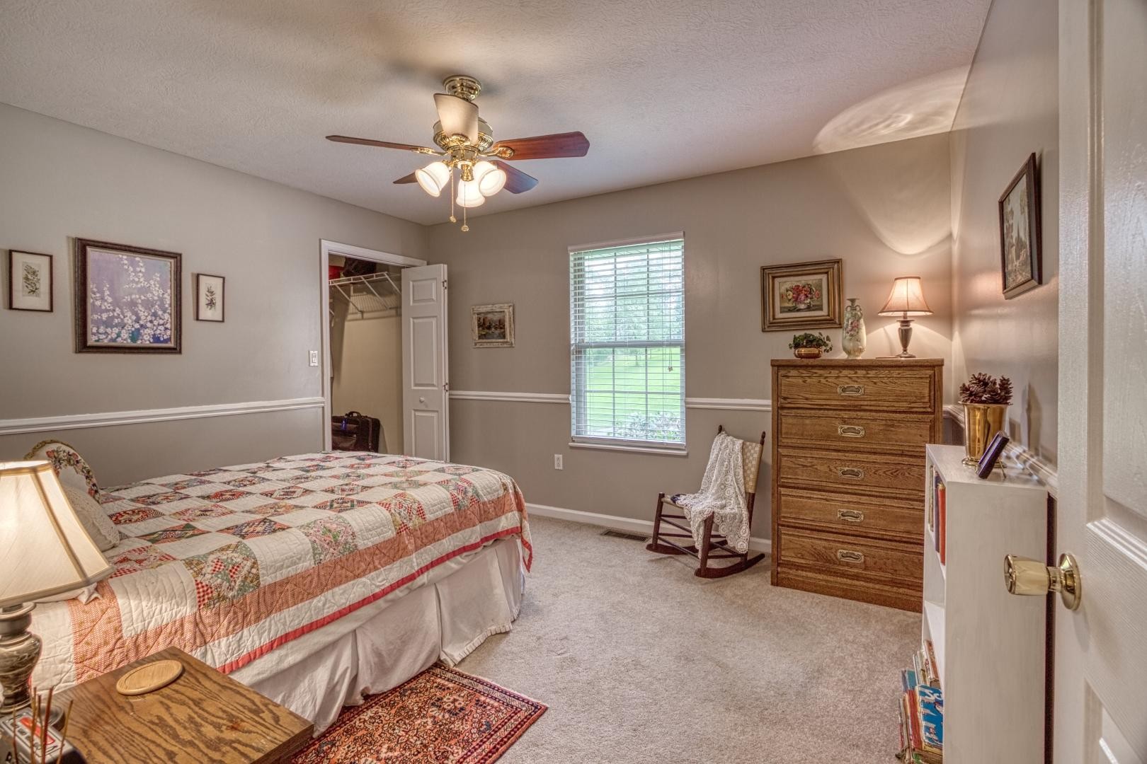 720 Rock House Road Kodak, TN 37764 - Photo 8 of 18 a bedroom with a bed and a chandelier