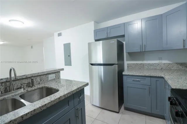 a kitchen with a refrigerator sink and cabinets
