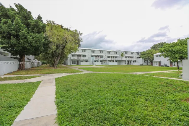 a view of a park with a house in the background