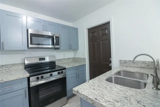 a kitchen with granite countertop a stove and a microwave