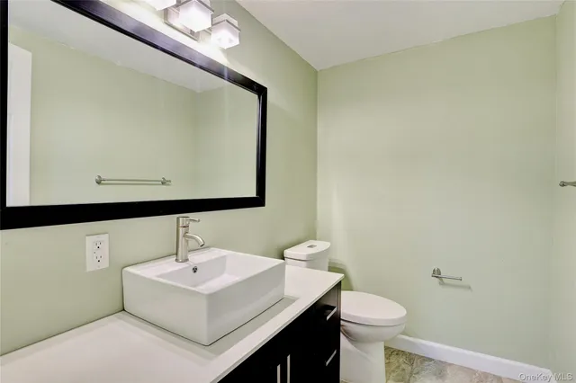 a bathroom with a sink mirror and toilet