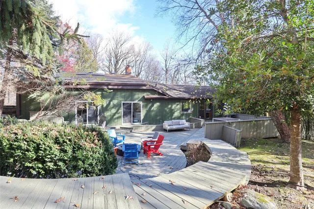 a view of a patio with table and chairs potted plants and large tree