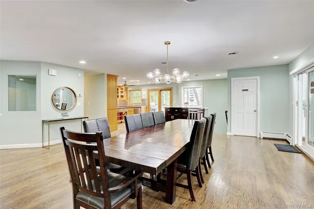 a view of a dining room and livingroom with furniture wooden floor a rug a fireplace