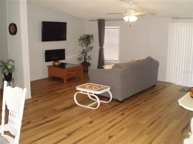 a living room with furniture a flat screen tv and a window