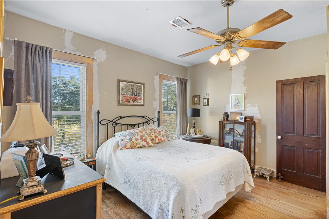 1017 Water Street Navasota, TX 77868 - Photo 20 of 28 a bedroom with a bed and a chandelier