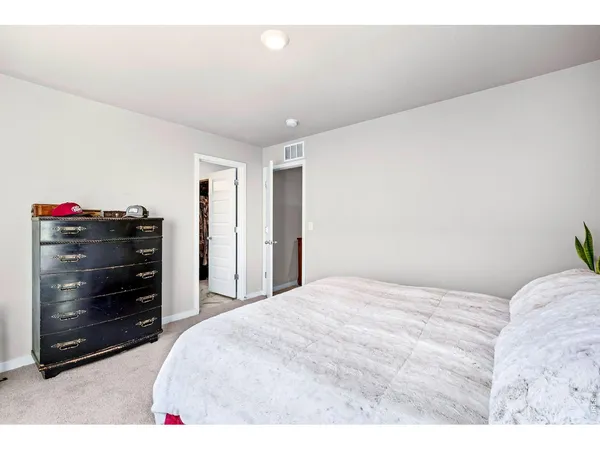 a bedroom with a bed and a dresser