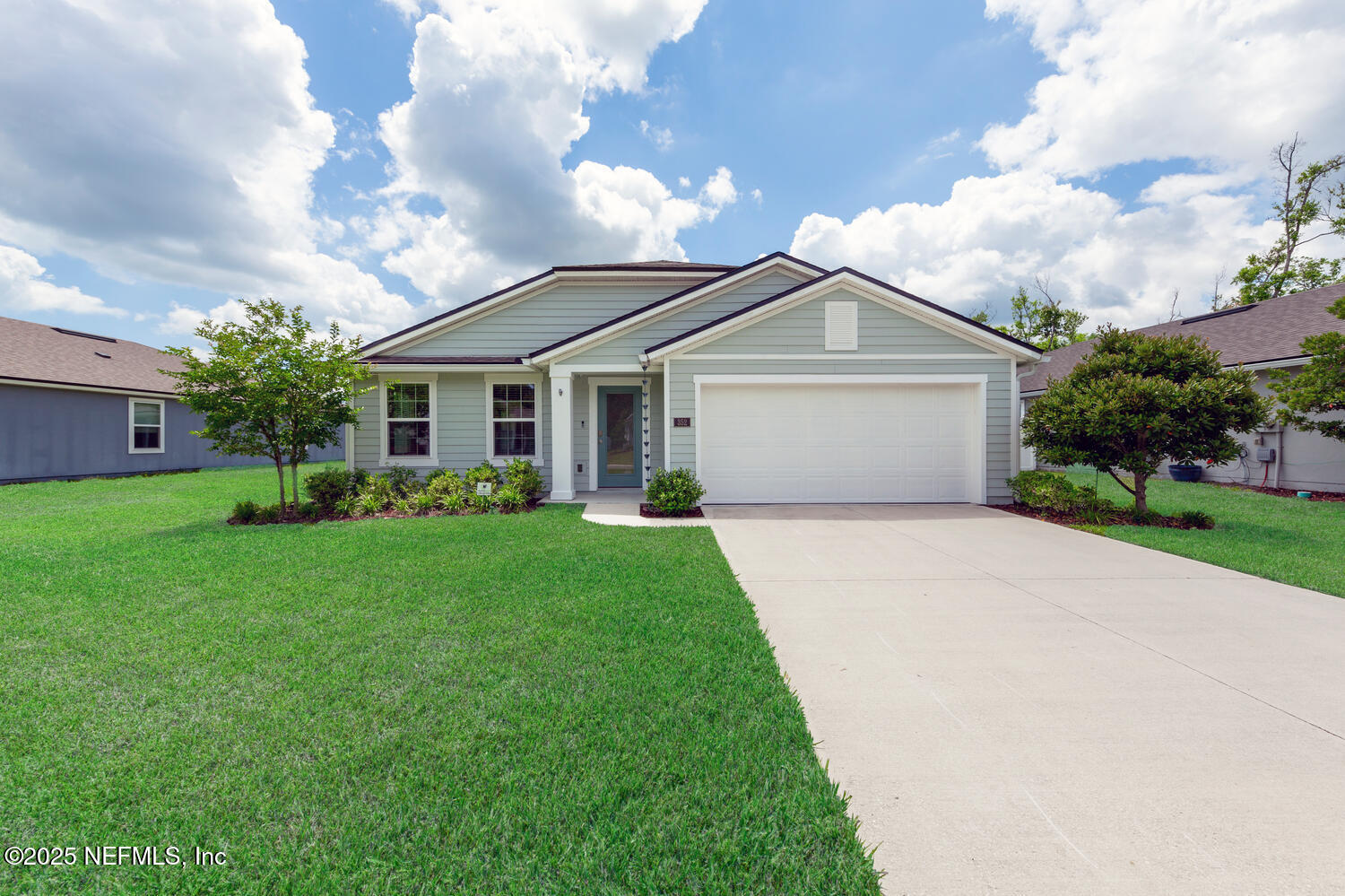 a front view of a house with a garden and yard