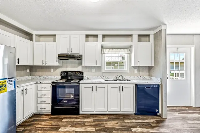 a kitchen with stainless steel appliances granite countertop a stove and cabinets