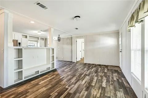 a view of a big room with wooden floor and windows