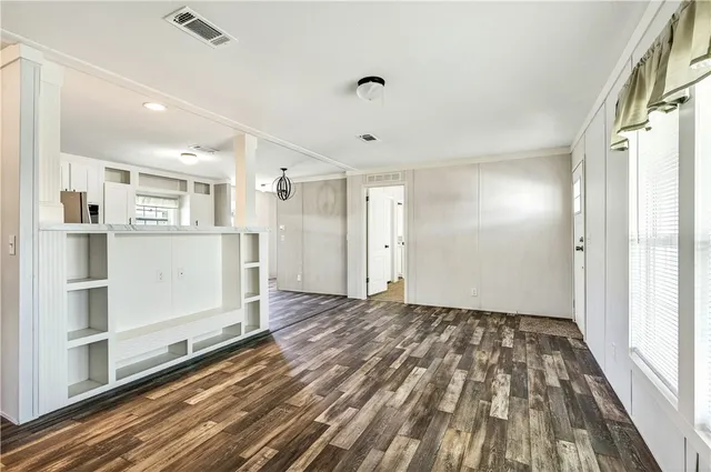a view of a big room with wooden floor and windows