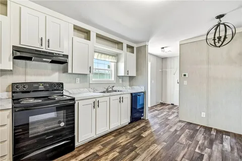 a kitchen with granite countertop a stove and cabinets