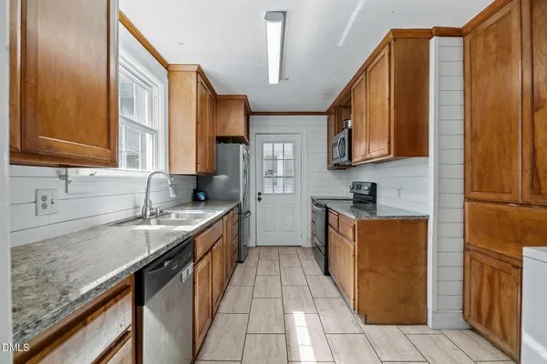 a kitchen with stainless steel appliances granite countertop a sink stove and cabinets