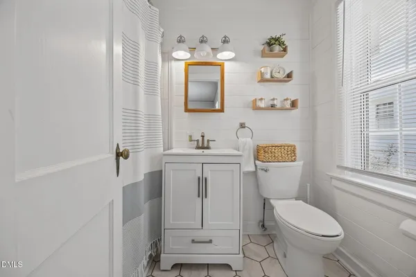 a bathroom with a sink toilet vanity and mirror