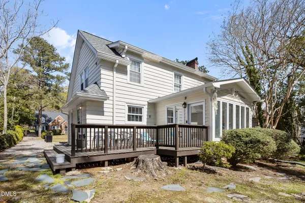 a view of a house with wooden deck and furniture