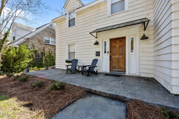 a backyard of a house with barbeque oven table and chairs