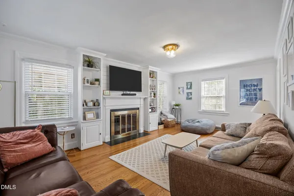 a living room with furniture a flat screen tv and a fireplace