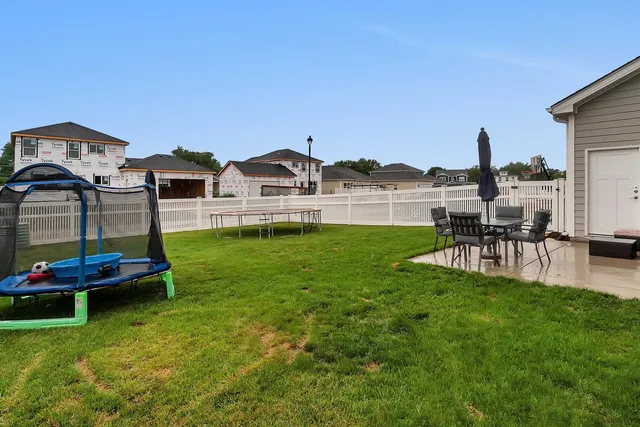 a backyard of a house with table and chairs
