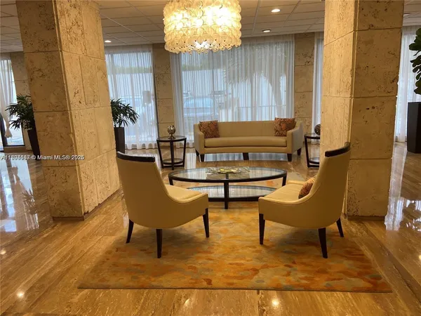 a living room with a furniture and a chandelier