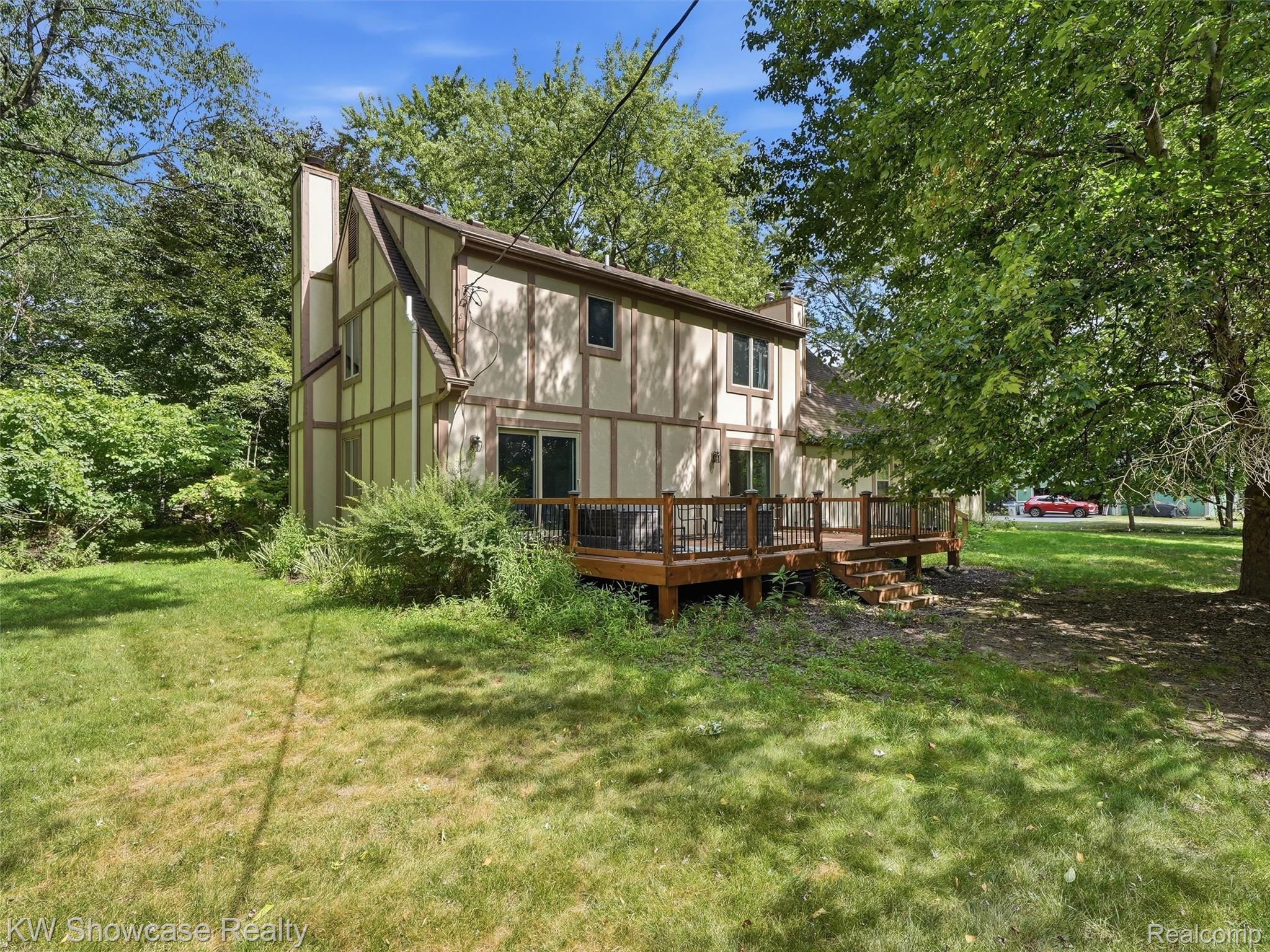 3360 Pleasant Valley Road Brighton, MI 48114 - Photo 44 of 60 Tudor-style exterior featuring a multi-level wood deck with dark railings