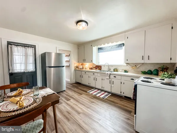 a kitchen with refrigerator cabinets and wooden floor